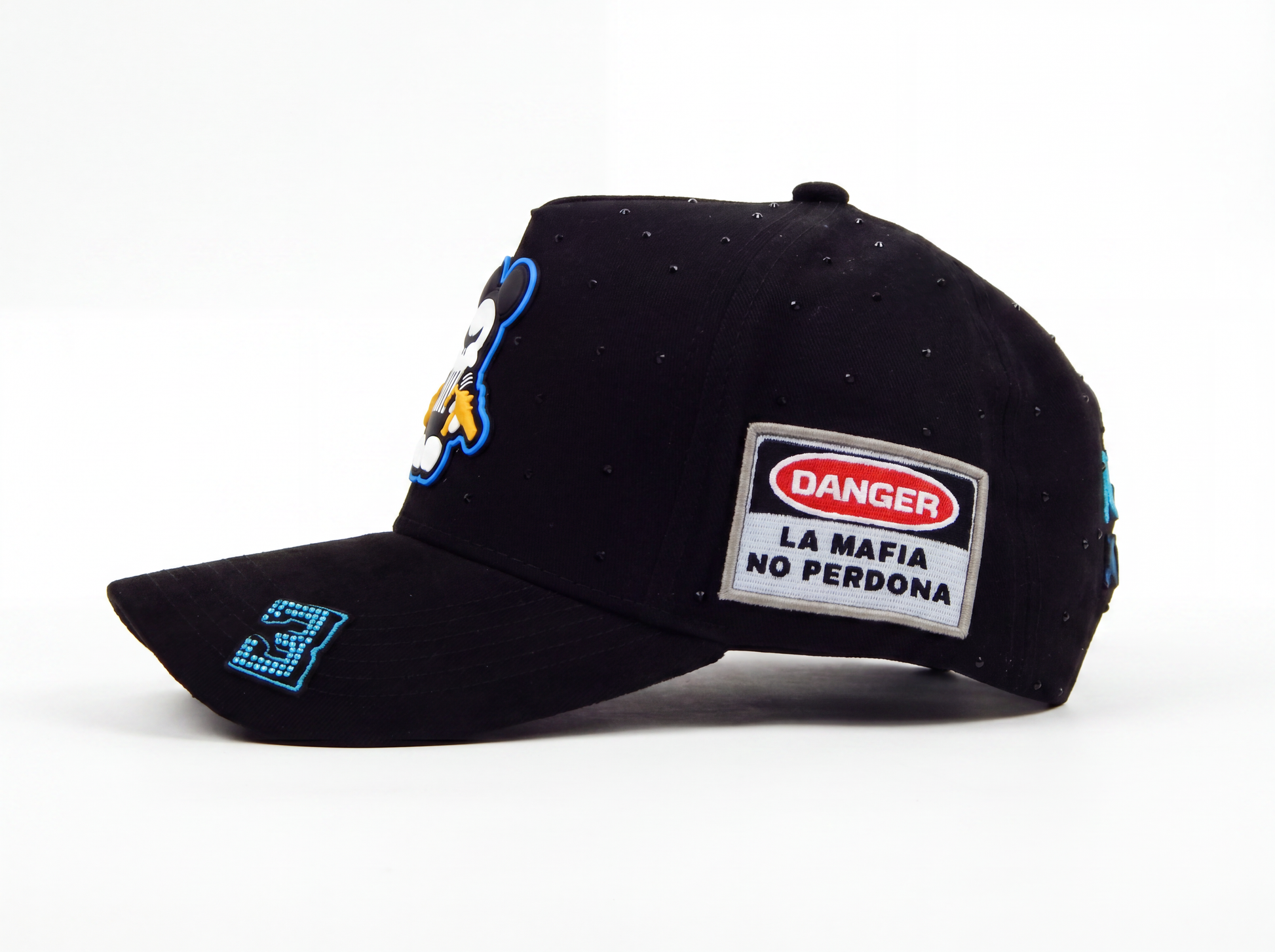 Black baseball cap with a cartoon penguin patch on the front, a rectangular 'DANGER LA MAFIA NO PERDONA' patch on the side, and a blue embroidered '3'